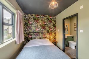een slaapkamer met een bed met een bloemenbehang bij Bondgate House in Alnwick