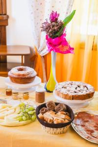 a table with cakes and pies and a vase with flowers at Tenuta MalescioQuintieri in Fagnano Castello