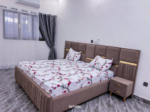 una camera da letto con un grande letto decorato con fiori rossi di Magnifique Mini-Villa Ouagadougou! a Ouagadougou