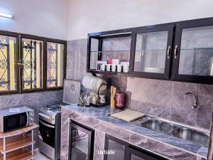 una cucina con lavello, piano cottura e armadietti di Magnifique Mini-Villa Ouagadougou! a Ouagadougou
