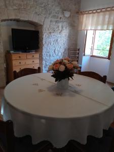 a white table with a vase of flowers on it at Appartment Plaza in Krnica