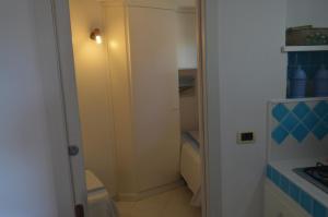 une petite salle de bain avec un placard avec une porte dans l'établissement Casa Lantana, à Porto Taverna 31 autres photos