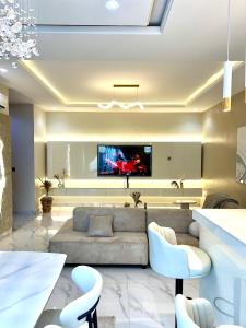 a living room with a couch and a tv on a wall at The Ivory Luxe Suit Lekki phase 1 Lagos in Lagos