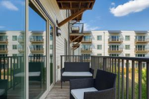 a balcony with two chairs and a building at Spacious 2BR 2BA Condo Across from UAB in Homewood