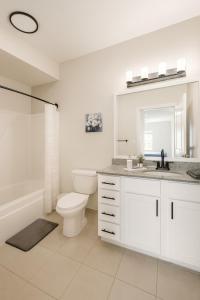 a white bathroom with a toilet and a sink at Spacious 2BR 2BA Condo Across from UAB in Homewood +18 photos
