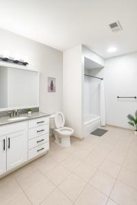 a white bathroom with a toilet and a sink at Across from UAB Spacious 2BR Retreat 2nd in Homewood