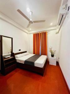 a bedroom with a bed and a mirror in it at Peridot Open Sky T Garden in Bandarawela
