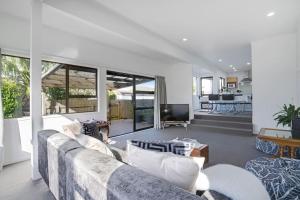 een woonkamer met een bank en een tv bij Parnell Home with Pool, Parking and Rangitoto View in Auckland