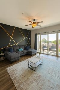 a living room with a couch and a ceiling fan at Luxury 2BR Condo Steps from UAB Campus 4th in Homewood