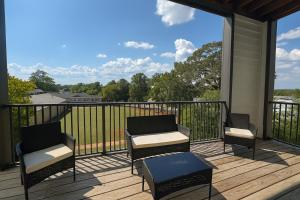 a balcony with two chairs and a table on a deck at Luxury 2BR Condo Steps from UAB Campus 4th in Homewood