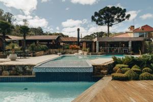 a swimming pool in a yard with a house at Spa Estância do Lago in Almirante Tamandaré