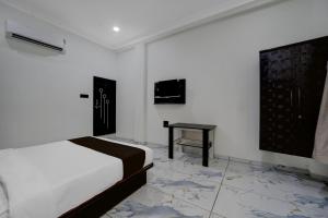 a white bedroom with a bed and a table at Hotel O Choice Inn II in Rao