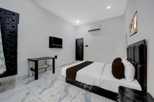 a white bedroom with a bed and a desk at Hotel O Choice Inn II in Rao