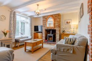 a living room with a couch and a fireplace at Mill Pond Cottage in Sheringham