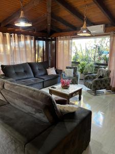 una sala de estar con un sofá y una mesa en Casa ampla com área gourmet e piscina, en Capão da Canoa