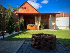 a house with a brick fire pit in the yard at B&B House in Obreja