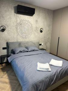 a bedroom with a bed with two towels on it at Marių namai in Kaunas