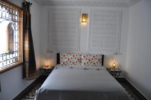 um quarto com uma cama e dois abajures em duas mesas em Riad Tafoukt Fes em Fez