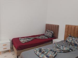 a bedroom with a bed and two beds with pillows at Jamila 3 in Midoun
