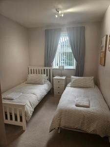 une chambre avec deux lits et une fenêtre dans l'établissement Bargh Apartment - 2 bed 2 bath, modern comfort, à Balderton