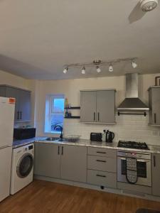 une cuisine avec un évier et une cuisinière four supérieur dans l'établissement Bargh Apartment - 2 bed 2 bath, modern comfort, à Balderton