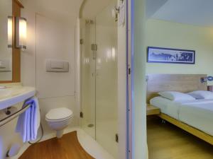 a bathroom with a bed and a shower and a toilet at ibis Bengaluru Outer Ring Road in Bengaluru +63 photos