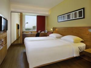 a hotel room with two beds and a television at ibis Bengaluru Outer Ring Road in Bengaluru