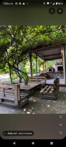 a group of wooden picnic tables in a park at Hostel Kuku in Mina Clavero +7 photos