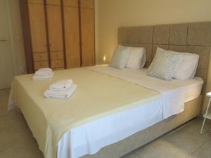 ein Schlafzimmer mit einem großen Bett mit Handtüchern darauf in der Unterkunft ELIRA - City Apartment, Lefkada in Lefkada Town