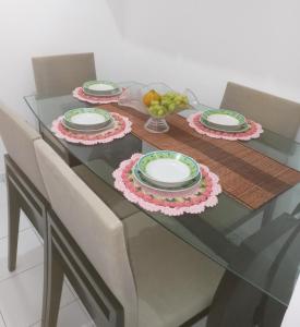 una mesa de cristal con dos platos y un bol de fruta en Quarto casal, en Vitória