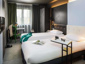 een hotelkamer met twee bedden en een tafel bij ibis Styles London Southwark - near Borough Market in Londen