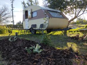 an rv sitting on a trailer in a field at DDR Wohnwagen QEK AERO in Sandau