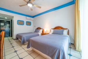 a bedroom with two beds and a ceiling fan at Hotel Autlan in Autlán de Navarro +24 photos