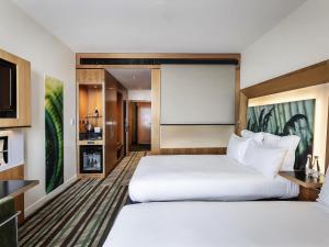 una camera d'albergo con due letti e una TV a schermo piatto di Novotel Auckland Airport ad Auckland Altre 52 foto