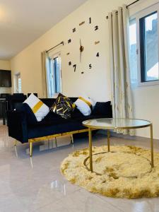 a living room with a couch and a clock on the wall at Sxm Sea View Apartments in Philipsburg