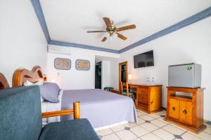 a bedroom with a bed and a ceiling fan at Hotel Autlan in Autlán de Navarro