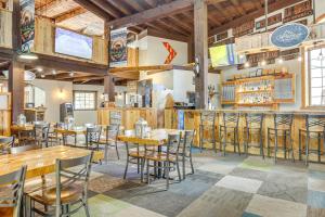 a restaurant with tables and chairs and a bar at Ski-InandSki-Out Condo in Upson - Walk to Lake in Upson
