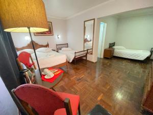 a hotel room with two beds and a table and chairs at Nuevo Hotel in Rivera +79 photos