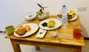 a wooden table with two plates of food and drinks at Hello Rafiki Stone town in Zanzibar City