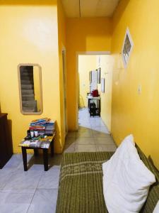 a room with a bed and a table and yellow walls at Próximo ao Hangar - COP30 in Belém