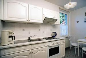 a kitchen with a sink and a stove top oven at Haus Nordseegruß 2 in Cuxhaven +7 photos