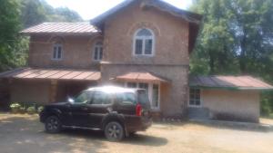 a black truck parked in front of a house at Raj Kot in Nainital