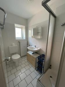 Un baño con lavabo, inodoro y ducha. en Haus Nordseegruß 3, en Cuxhaven