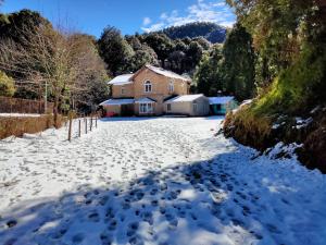 a snow covered driveway with a house in the background at Raj Kot in Nainital