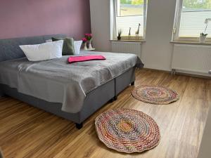 a bedroom with a bed and two rugs on the floor at Parkblick in Thale