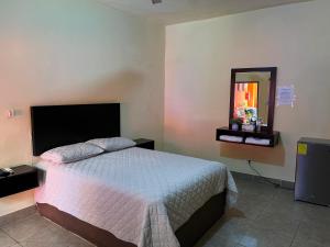 a bedroom with a bed and a mirror at HOTEL POSADA DEL CORTEZ in La Paz