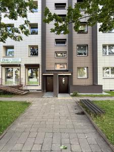 a building with a bench in front of it at Cozy Self Check-in CITY CENTRE apartment in Mažeikiai