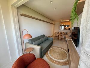 a living room with a couch and a dining room at Studio Design 3 Apt 801 -Mandi Hospitalidade in Maceió