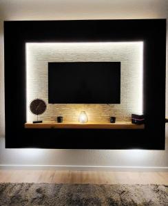a television on a brick wall with a shelf at Zentral wohnen in der Mainzer City in Mainz