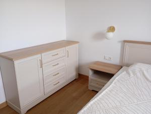 a white bedroom with a bed and a desk at Górski Wypoczynek in Szczawnica